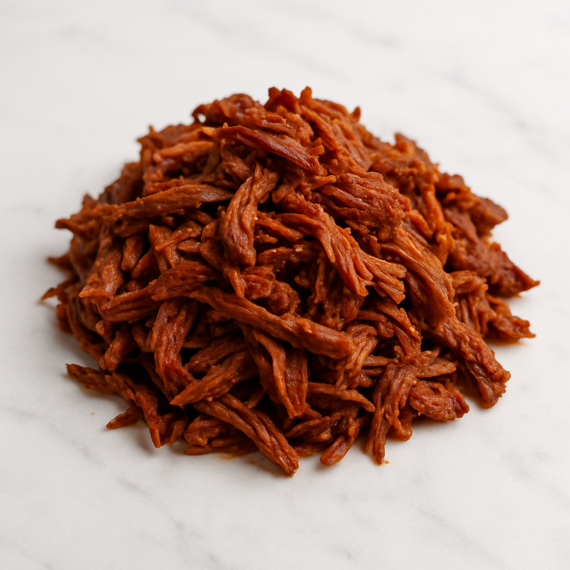 Birria de res cocida y deshebrada